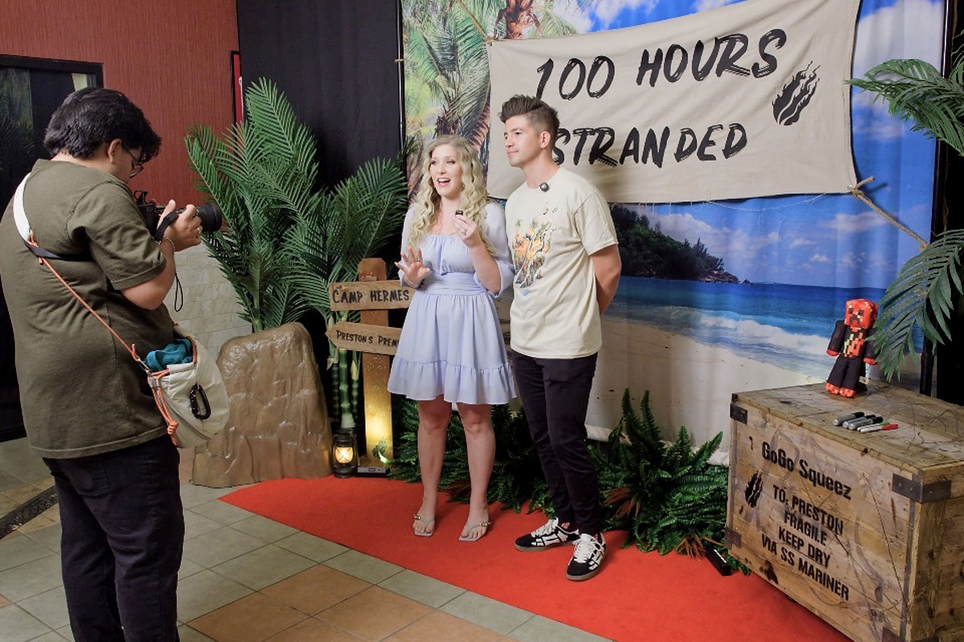 Creators on the red carpet at the PrestonPlayz premiere, in front of a "100 Hours Stranded" banner